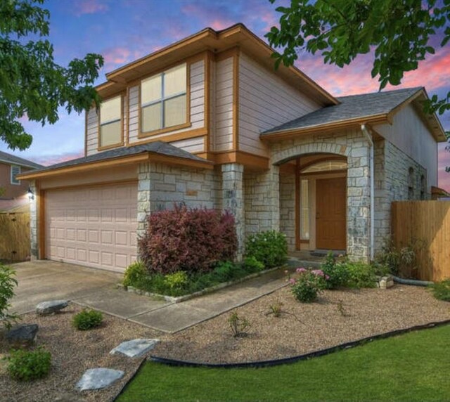13306 James Monroe St, Manor, TX 78653 - split level home featuring stone siding, driveway, and an attached garage