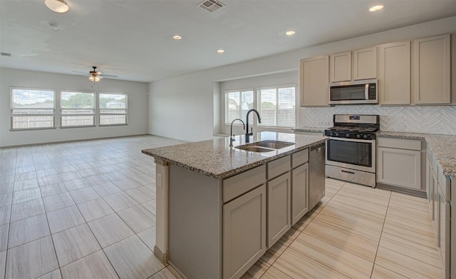 286 Spinnaker Loop, Kyle, TX 78640 - kitchen with stainless steel appliances, a sink, backsplash, a ceiling fan, and a kitchen island with sink