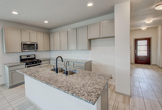 286 Spinnaker Loop, Kyle, TX 78640 - kitchen with stainless steel appliances, a sink, gray cabinetry, light stone countertops, and backsplash