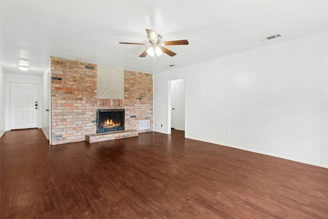 unfurnished living room featuring ceiling fan, wood finished floors, a fireplace, and baseboards