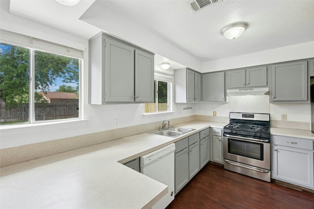 kitchen with stainless steel gas range, a sink, dishwasher, gray cabinetry, and under cabinet range hood
