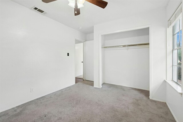 unfurnished bedroom featuring carpet floors, a closet, and ceiling fan