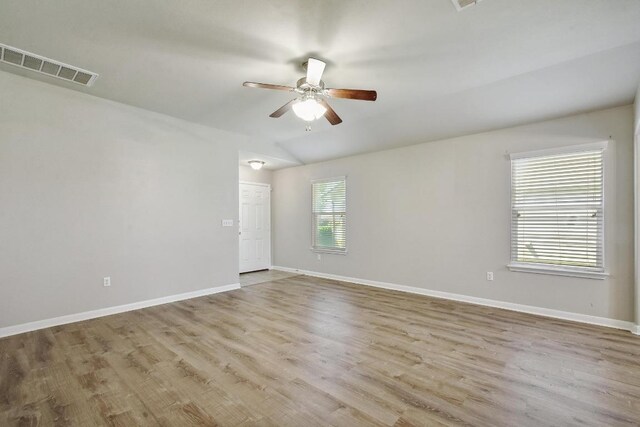 352 Voyager Cv, Kyle, TX 78640 - empty room with ceiling fan, wood finished floors, baseboards, and lofted ceiling