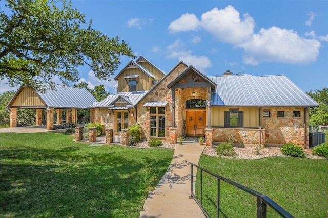 1150 Windmill Run, Wimberley, TX 78676 - view of front facade with stone siding, a standing seam roof, metal roof, and a front yard