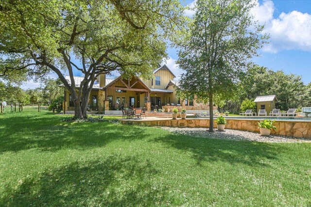 1150 Windmill Run, Wimberley, TX 78676 - view of green lawn with a patio area, a pool, and an outdoor structure