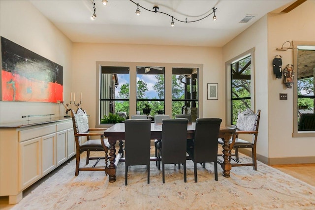 1150 Windmill Run, Wimberley, TX 78676 - dining area with baseboards, rail lighting, and light wood-type flooring
