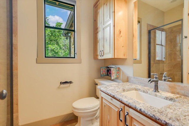 1150 Windmill Run, Wimberley, TX 78676 - bathroom featuring a stall shower, toilet, vanity, and baseboards
