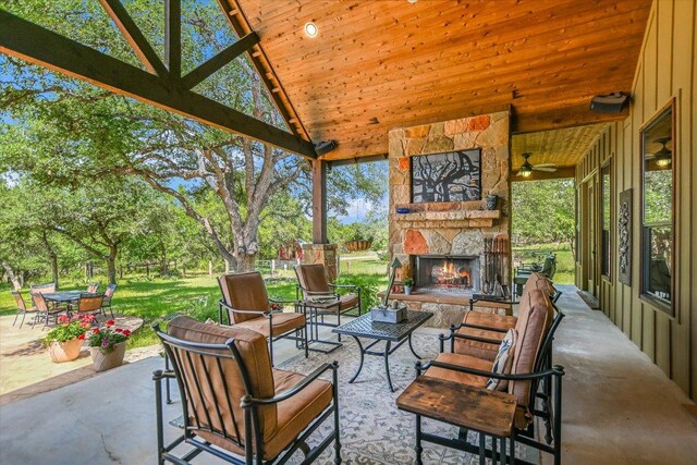 1150 Windmill Run, Wimberley, TX 78676 - view of patio featuring ceiling fan, an outdoor living space with a fireplace, and view of wooded area