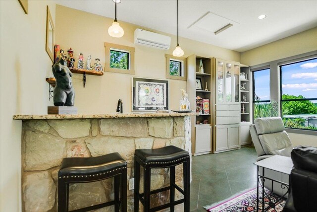 1150 Windmill Run, Wimberley, TX 78676 - bar with a wall mounted AC, finished concrete flooring, and decorative light fixtures