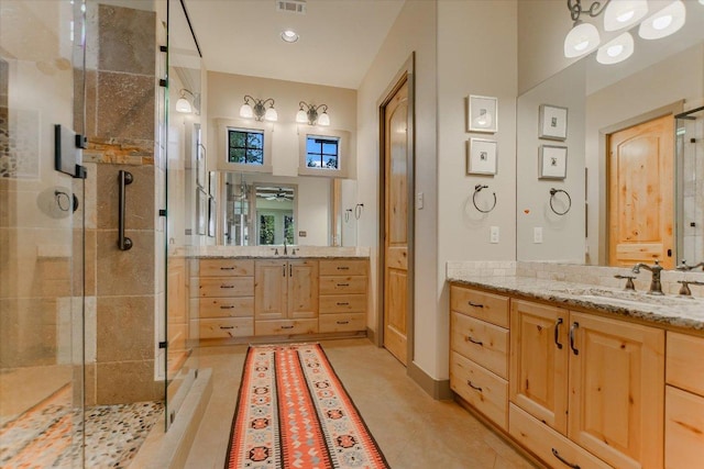 1150 Windmill Run, Wimberley, TX 78676 - full bath with a stall shower, two vanities, and a ceiling fan