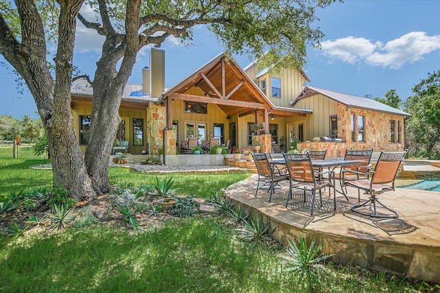 1150 Windmill Run, Wimberley, TX 78676 - rear view of house with board and batten siding, a patio, an outdoor pool, and metal roof