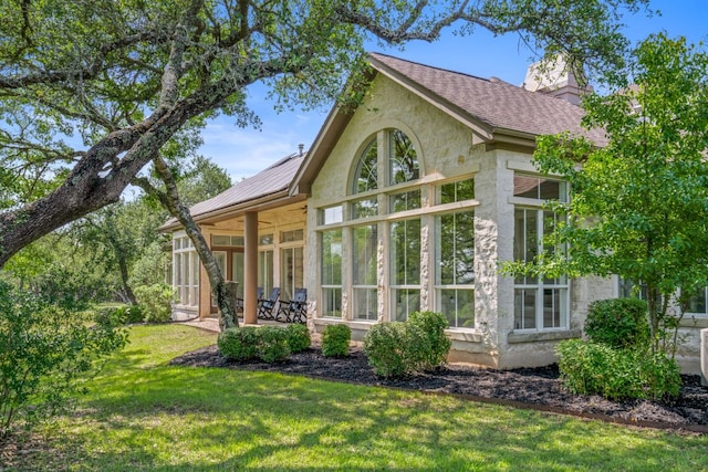 325 Onion Creek Ranch Rd, Driftwood, TX 78619 - back of house with a lawn, stucco siding, a sunroom, a chimney, and roof with shingles