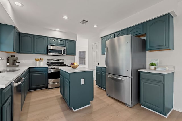 13223 Darwin Ln, Austin, TX 78729 - kitchen with stainless steel appliances, a sink, light wood-style flooring, light countertops, and a kitchen island