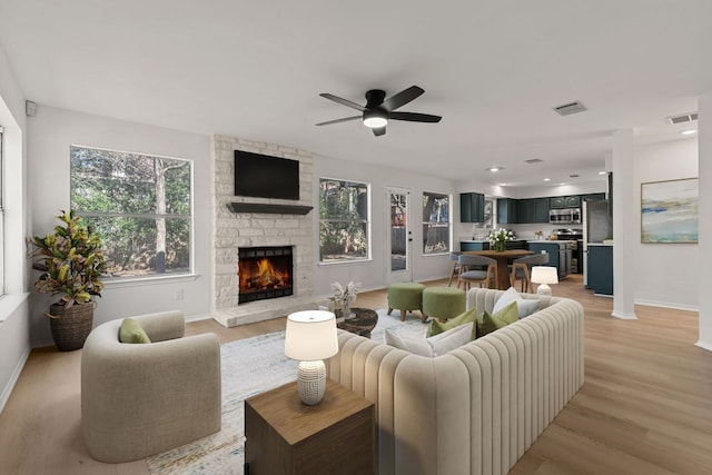 13223 Darwin Ln, Austin, TX 78729 - living room featuring a fireplace, baseboards, light wood-style floors, and ceiling fan