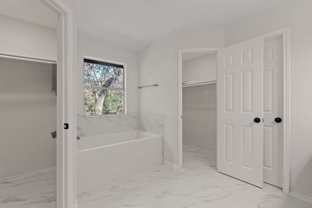 13223 Darwin Ln, Austin, TX 78729 - bathroom featuring marble finish flooring, a bath, a walk in closet, and baseboards