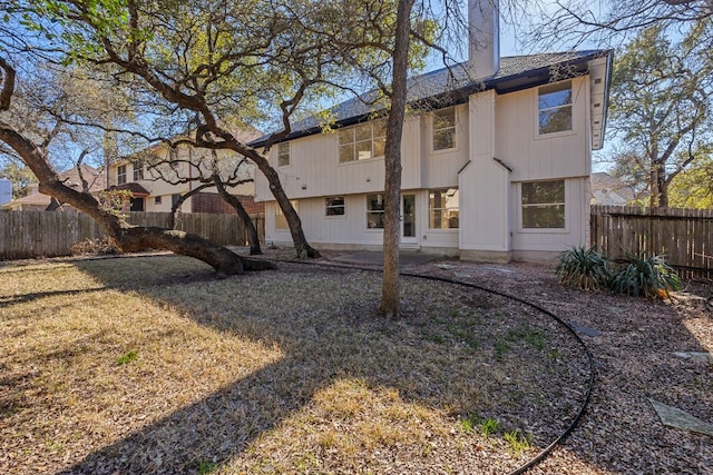 13223 Darwin Ln, Austin, TX 78729 - back of property featuring a fenced backyard, a patio, and a chimney