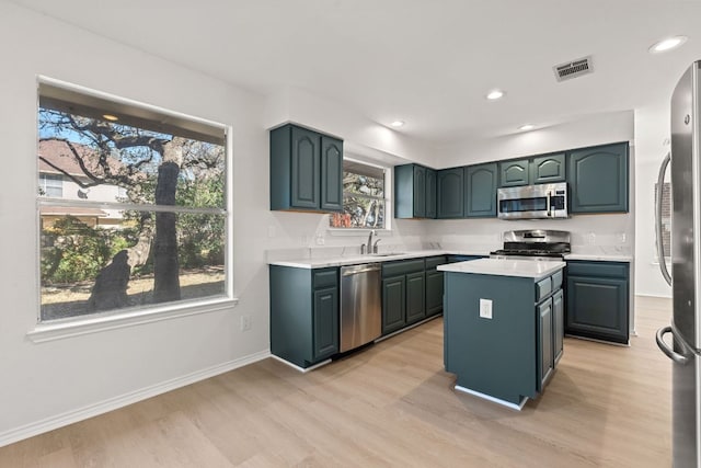 13223 Darwin Ln, Austin, TX 78729 - kitchen with stainless steel appliances, a sink, light wood-type flooring, light countertops, and recessed lighting
