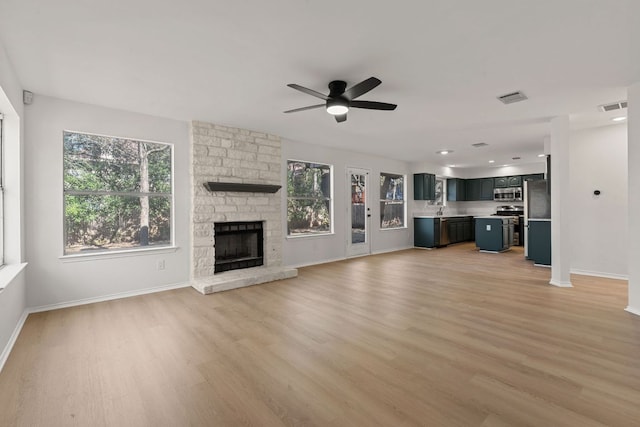 13223 Darwin Ln, Austin, TX 78729 - unfurnished living room featuring ceiling fan, light wood-style floors, a fireplace, and baseboards