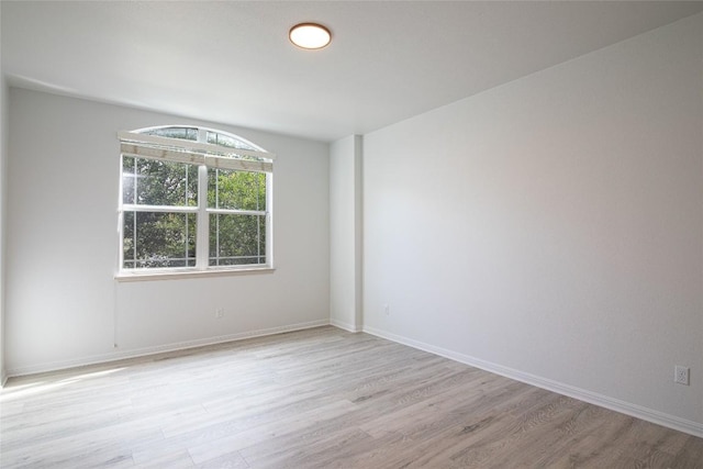 unfurnished room with light wood finished floors and baseboards