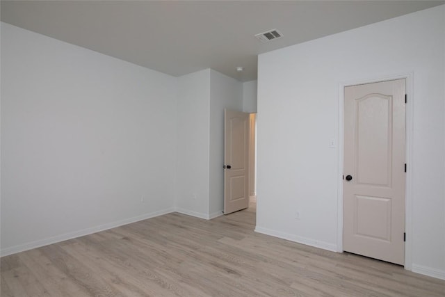 empty room featuring light wood-type flooring and baseboards