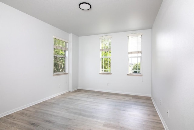 unfurnished room with light wood-style flooring and baseboards
