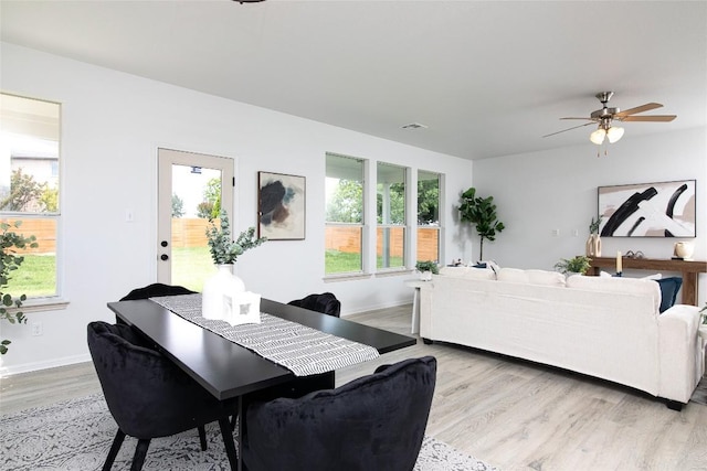 dining room with light wood-style floors, healthy amount of natural light, and ceiling fan