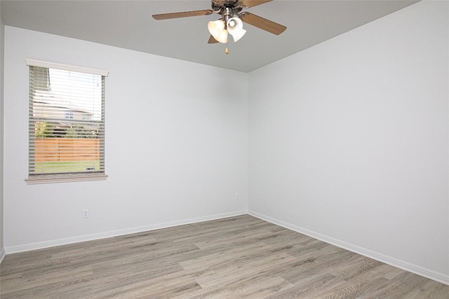 spare room with light wood-style floors, ceiling fan, and baseboards
