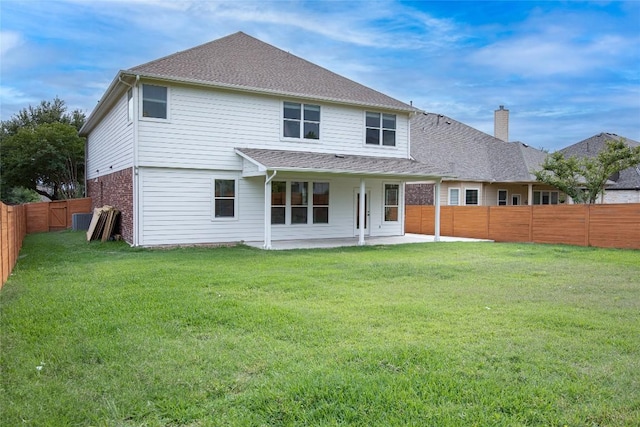rear view of house with a patio area, a chimney, brick siding, and roof with shingles