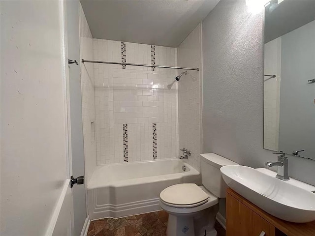 202 Prima St Unit A, Smithville, TX 78957 - full bathroom with toilet, vanity, shower / bathtub combination, a textured wall, and stone finish floors