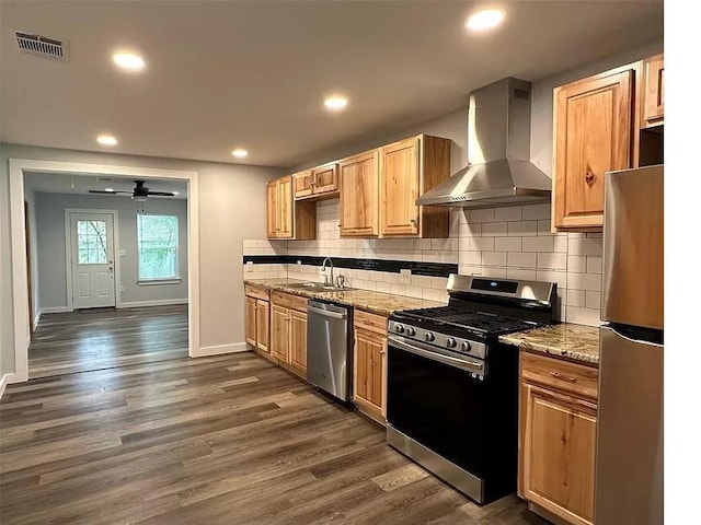202 Prima St Unit A, Smithville, TX 78957 - kitchen with appliances with stainless steel finishes, wall chimney exhaust hood, a sink, dark wood-style floors, and baseboards