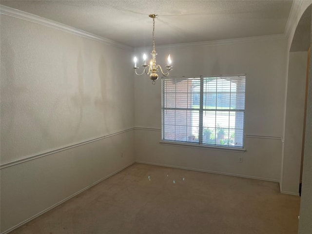 unfurnished room featuring carpet, a chandelier, crown molding, and baseboards