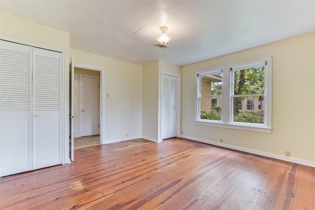 503 Colorado St, Smithville, TX 78957 - unfurnished bedroom featuring multiple closets, light wood-type flooring, and baseboards