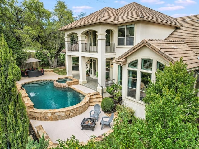 11701 Hunters Green Trl, Austin, TX 78732 - back of property featuring a balcony, a patio area, stucco siding, and a tiled roof
