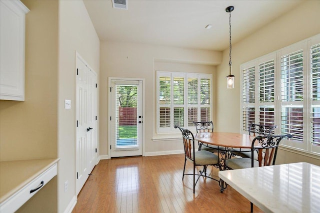 dining space featuring light wood-style floors and baseboards