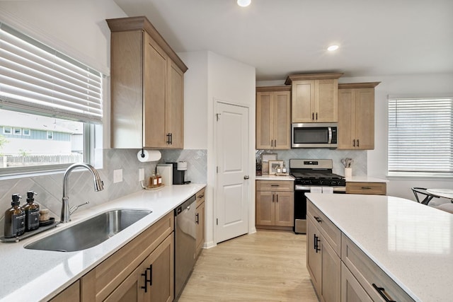 615 Backstays Loop, Kyle, TX 78640 - kitchen with appliances with stainless steel finishes, a sink, light wood-style flooring, backsplash, and light stone countertops