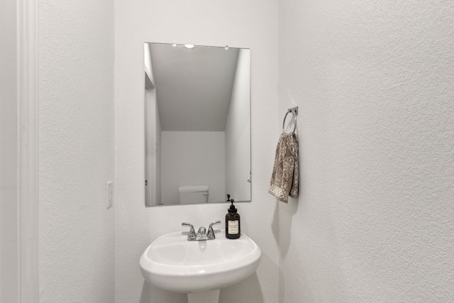 615 Backstays Loop, Kyle, TX 78640 - half bathroom featuring a sink, a textured wall, and toilet
