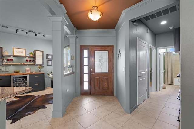 214 Fieldstone Dr, Georgetown, TX 78633 - foyer entrance featuring ornate columns, beverage cooler, light tile patterned flooring, and a bar
