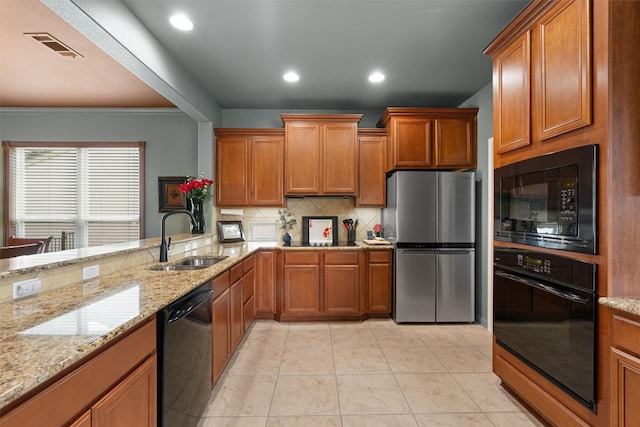214 Fieldstone Dr, Georgetown, TX 78633 - kitchen with black appliances, a sink, brown cabinetry, decorative backsplash, and recessed lighting