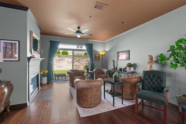 214 Fieldstone Dr, Georgetown, TX 78633 - living area with crown molding, hardwood / wood-style floors, a tiled fireplace, ceiling fan, and baseboards