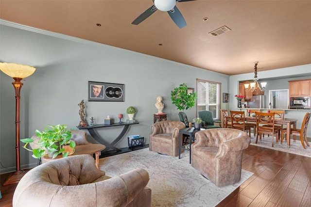 214 Fieldstone Dr, Georgetown, TX 78633 - living room featuring a chandelier, ceiling fan, ornamental molding, and dark wood-style flooring