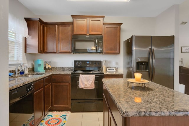 504 Sapphire Ln, Jarrell, TX 76537 - kitchen featuring black appliances, a sink, light stone countertops, and light tile patterned floors