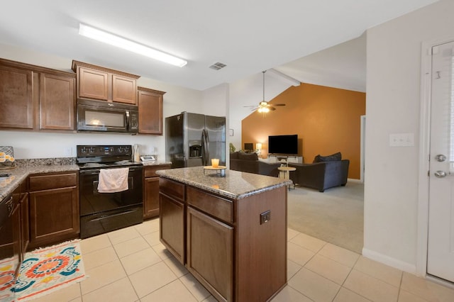 504 Sapphire Ln, Jarrell, TX 76537 - kitchen featuring black appliances, light tile patterned flooring, ceiling fan, a kitchen island, and lofted ceiling