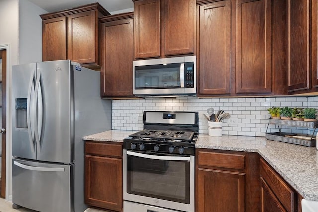 168 Pearl Way, Buda, TX 78610 - kitchen with appliances with stainless steel finishes, backsplash, and light stone countertops
