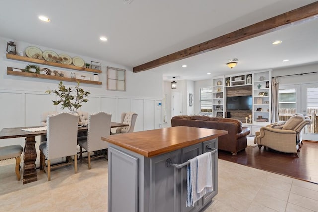 168 Pearl Way, Buda, TX 78610 - kitchen featuring light tile patterned flooring, a decorative wall, beam ceiling, a center island, and recessed lighting
