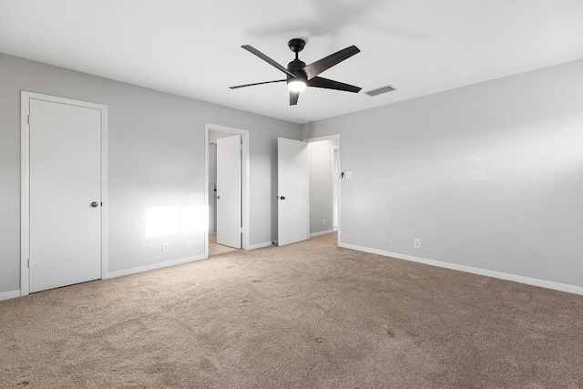 unfurnished bedroom featuring light colored carpet, baseboards, and a ceiling fan