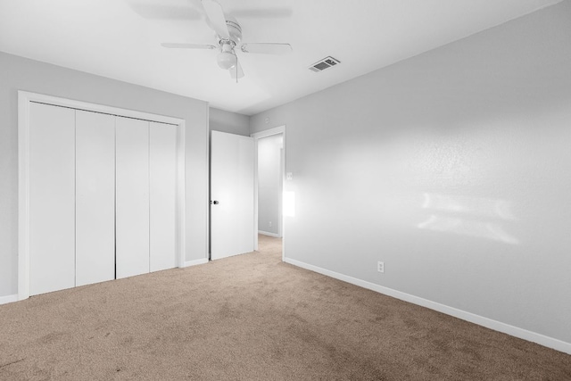 unfurnished bedroom featuring carpet floors, baseboards, a closet, and ceiling fan