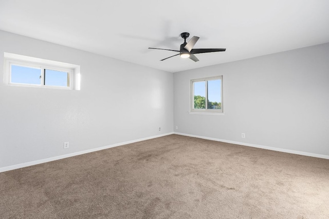 empty room featuring carpet floors, a ceiling fan, and baseboards
