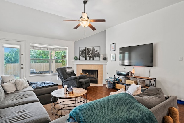 living room featuring wood finished floors, a tile fireplace, lofted ceiling, and a ceiling fan