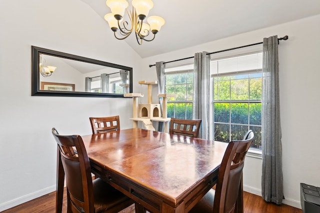 dining area featuring a chandelier, vaulted ceiling, dark wood-style flooring, and baseboards