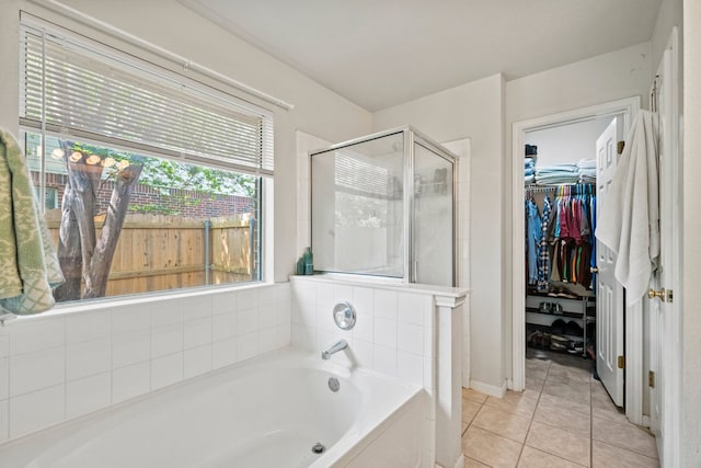 full bath featuring a shower stall, a garden tub, tile patterned flooring, and a walk in closet